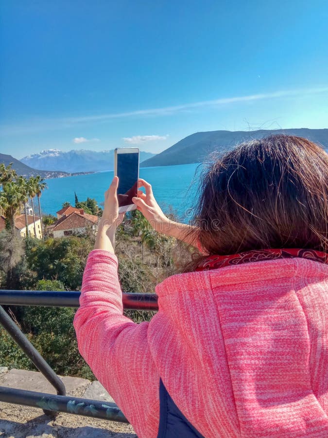 Woman traveling use smart phone and touching a mobile screen on mountain and sea. royalty free stock photo Woman traveling use smart phone and touching a mobile screen on mountain and sea. royalty free stock photo