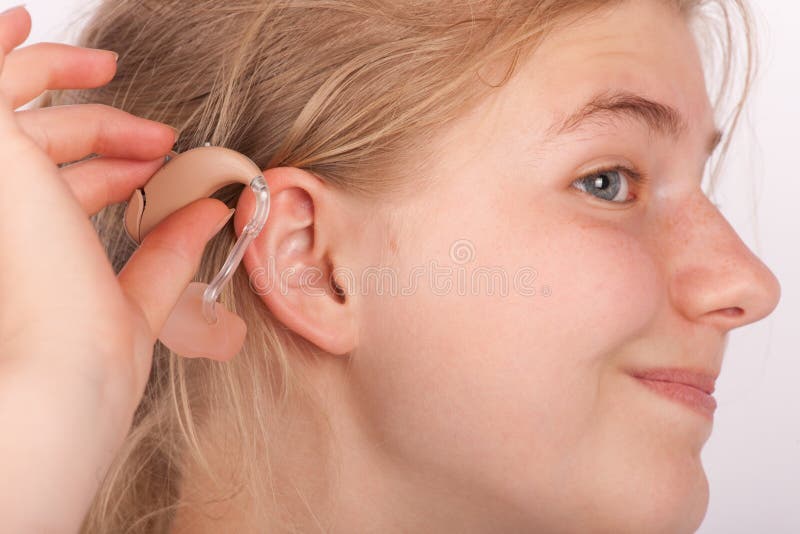 Woman trying to insert a hearing aid into ear