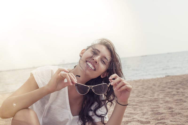 Woman in a tunic on the beach happy smiles and relaxes in the su stock photography Woman in a tunic on the beach happy smiles and relaxes in the su stock photography