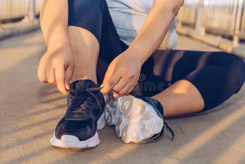 Woman tying shoelaces on a footbridge royalty free stock photography