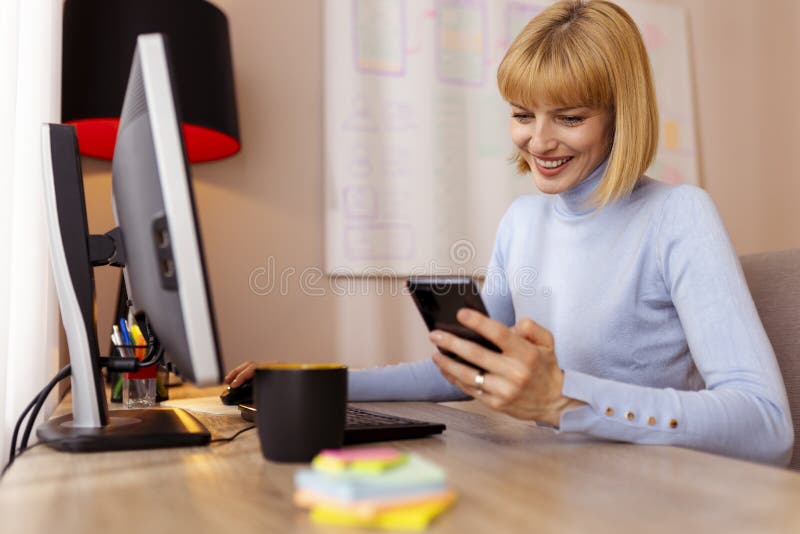 Woman Typing Text Message while Working in Home Office Stock Photo