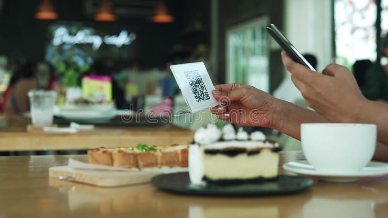 woman use mobile phone and open application for scanned the barcode to pay for cakes favors and desserts