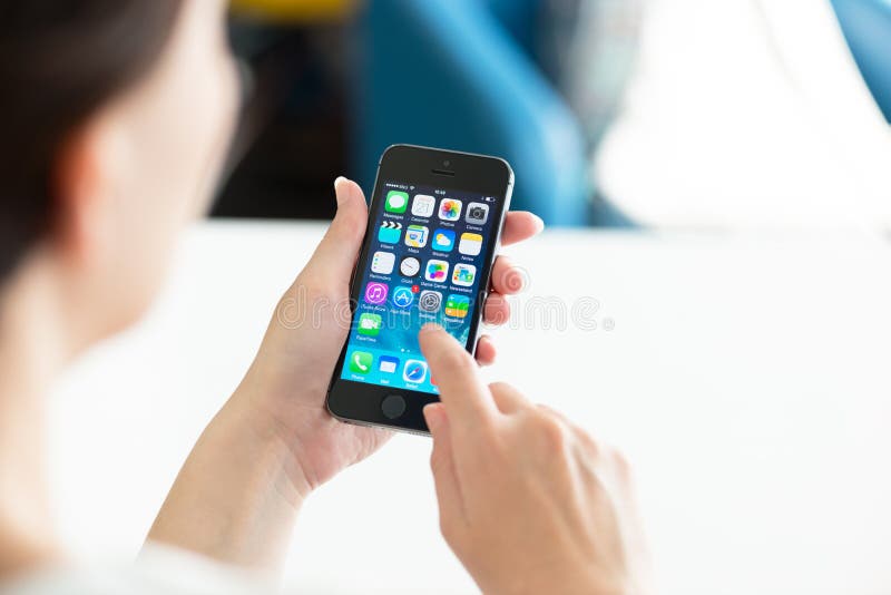 KIEV, UKRAINE - MAY 21, 2014: Woman holding brand new black Apple iPhone 5S, the most advanced smartphone in part of the iPhone line. Developed by Apple inc. and was released on September 20, 2013. KIEV, UKRAINE - MAY 21, 2014: Woman holding brand new black Apple iPhone 5S, the most advanced smartphone in part of the iPhone line. Developed by Apple inc. and was released on September 20, 2013.