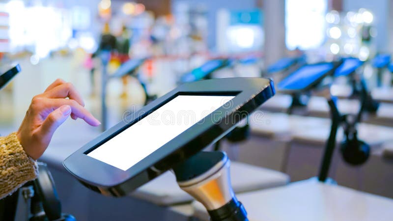 Woman using interactive touchscreen kiosk with white empty screen stock photography