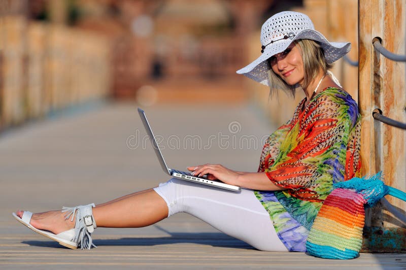 Woman using laptop outdoor in summer