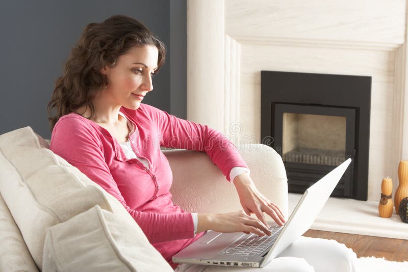 Woman Using Laptop Relaxing Sitting On Sofa