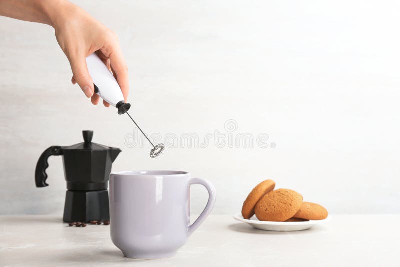 https://thumbs.dreamstime.com/b/woman-using-milk-frother-cup-table-space-text-128386562.jpg