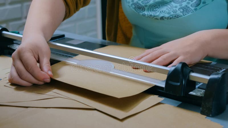 Woman using paper cutter, guillotine, designer working royalty free stock photography Woman using paper cutter, guillotine, designer working royalty free stock photography