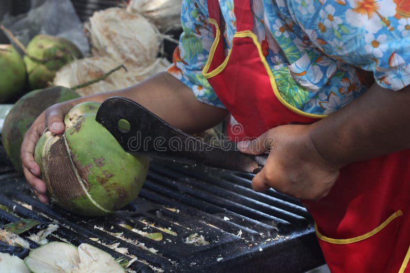 Woman is using a peeling coconut knife. Woman is using a peeling coconut knife for make coconut juice stock photos Woman is using a peeling coconut knife. Woman is using a peeling coconut knife for make coconut juice stock photos