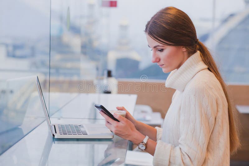 Woman using smart phone in modern cafe inerior stock images