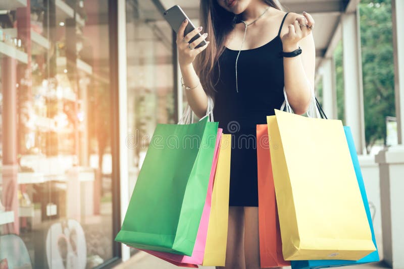 Woman using smartphone and checking sale promotion with holding royalty free stock image Woman using smartphone and checking sale promotion with holding royalty free stock image