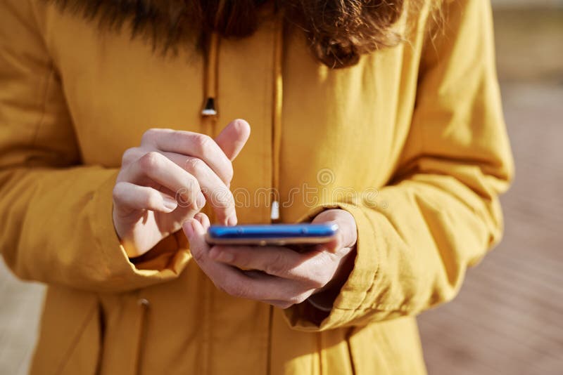 Woman using smartphone in the city outdoor, close up. Female hands typing message on mobile phone royalty free stock photo Woman using smartphone in the city outdoor, close up. Female hands typing message on mobile phone royalty free stock photo