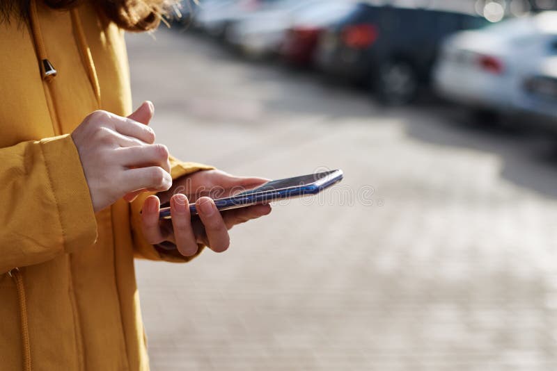 Woman using smartphone in the city outdoor, close up. Female hands typing message on mobile phone stock photo Woman using smartphone in the city outdoor, close up. Female hands typing message on mobile phone stock photo