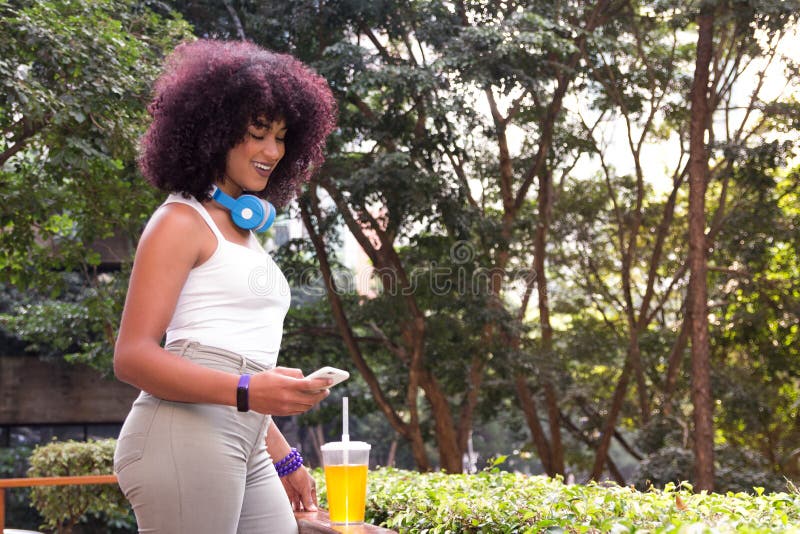 Woman using technology outdoors with cell phone and orange juice royalty free stock photography Woman using technology outdoors with cell phone and orange juice royalty free stock photography