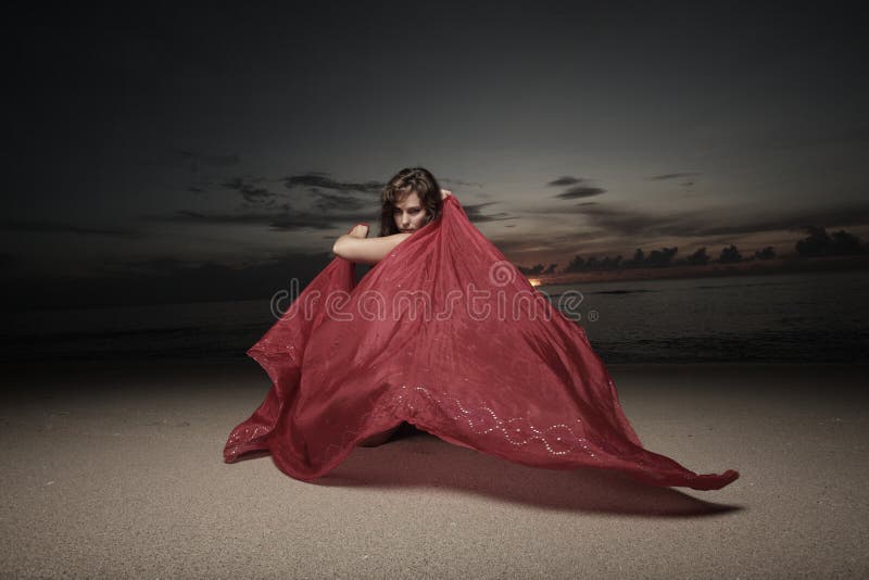 Woman with a veil on the beach