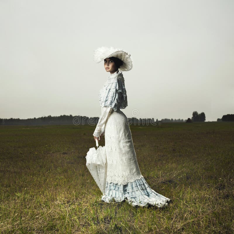 Schlanke Frau in vintage-Kleid für die Strandpromenade.