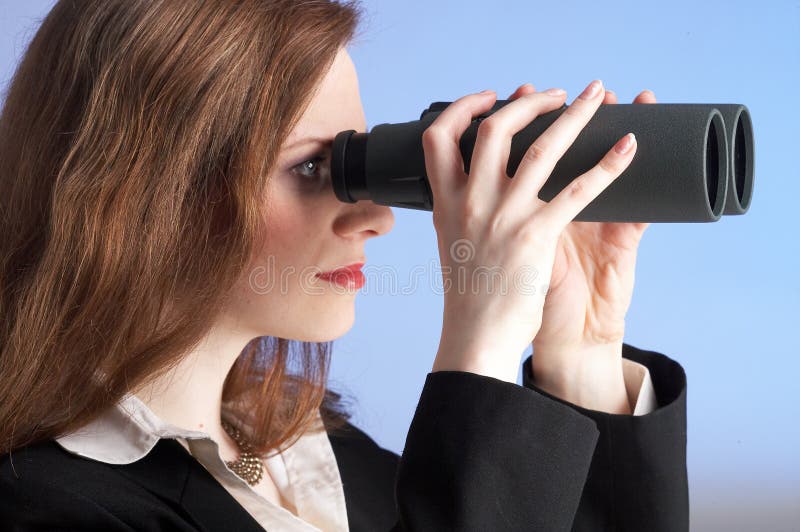 One businesswoman is looking trough field-glasses. One businesswoman is looking trough field-glasses