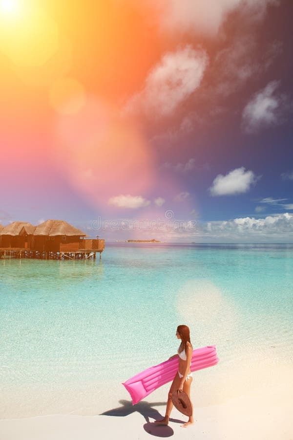 Woman walk and relax with inflatable mattress in the sea. Happy island lifestyle. White sand, crystal-blue sea of tropical beach.