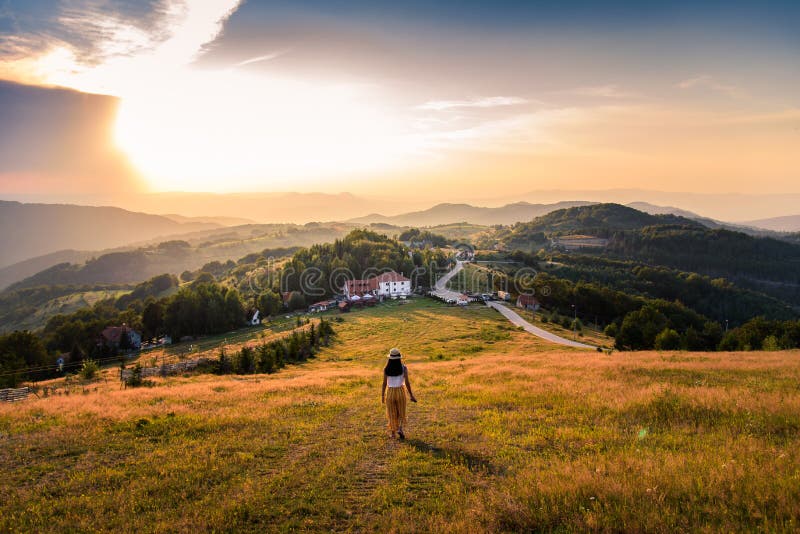 Woman walking down the hill at sunset