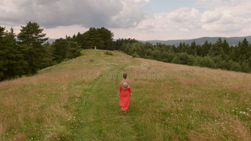 Woman walking hilltop forest road - camera follow