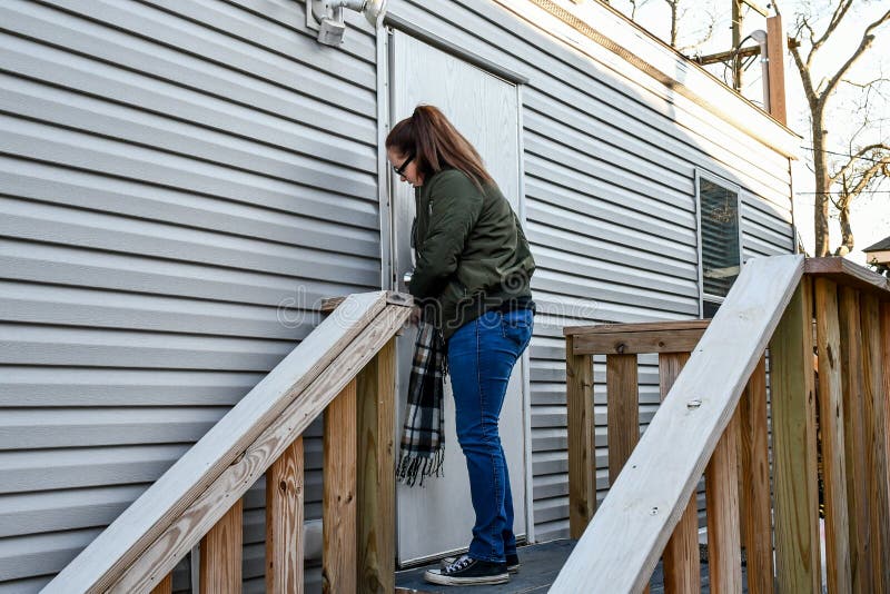 A woman locks her front door as she leaves home. royalty free stock image A woman locks her front door as she leaves home. royalty free stock image