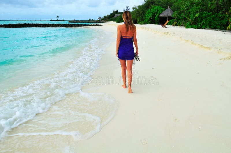 Woman walking on the sandy beach