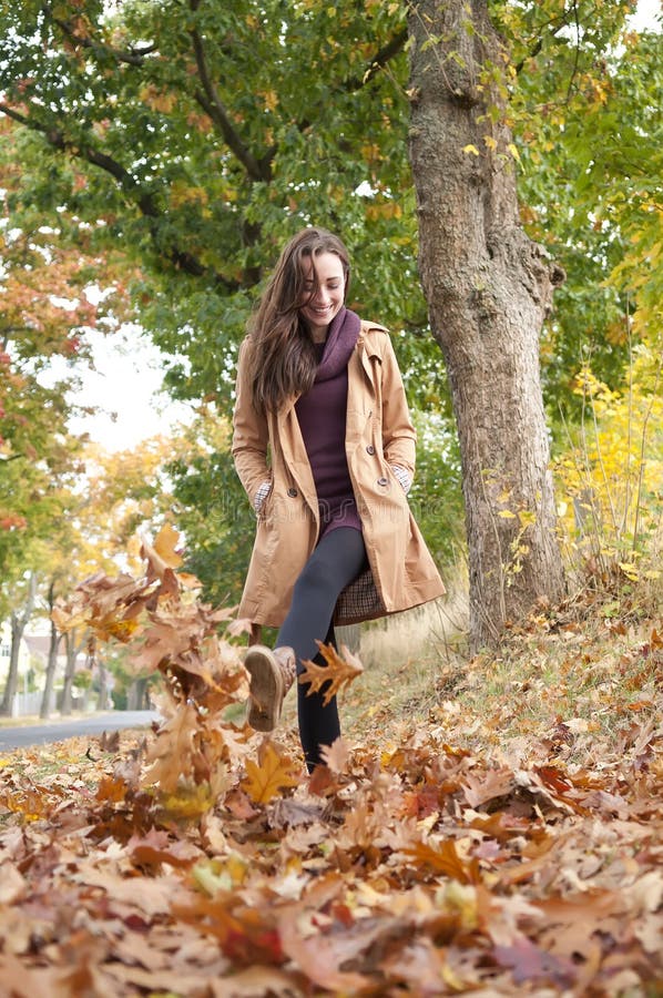 Woman walks in autumn leaves