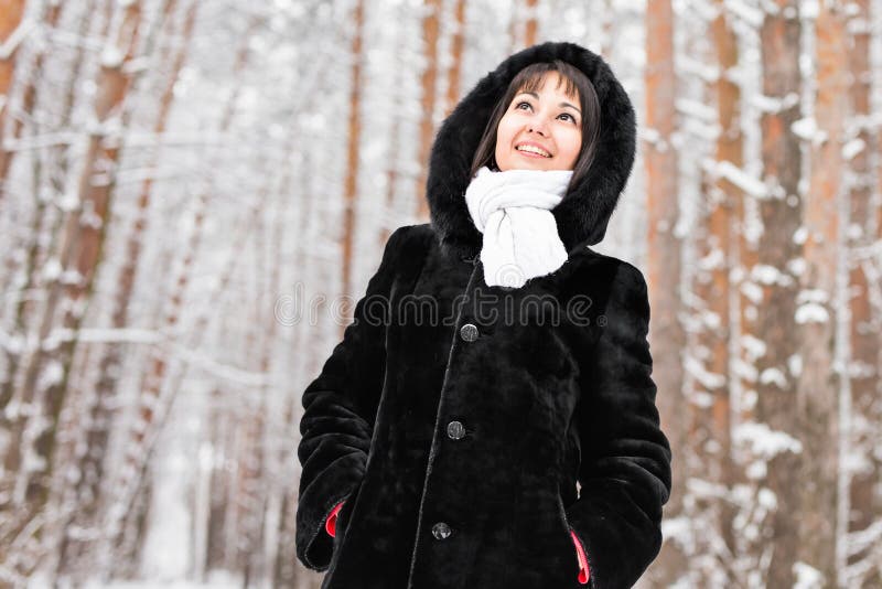 Woman in warm coat with fur in the forest, cold winter day. Frost, nature.