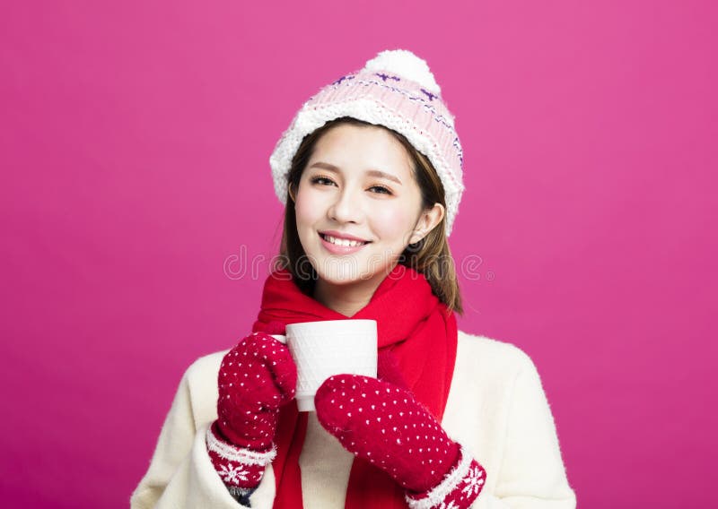 Woman in warm sweater drinking a cup of tea