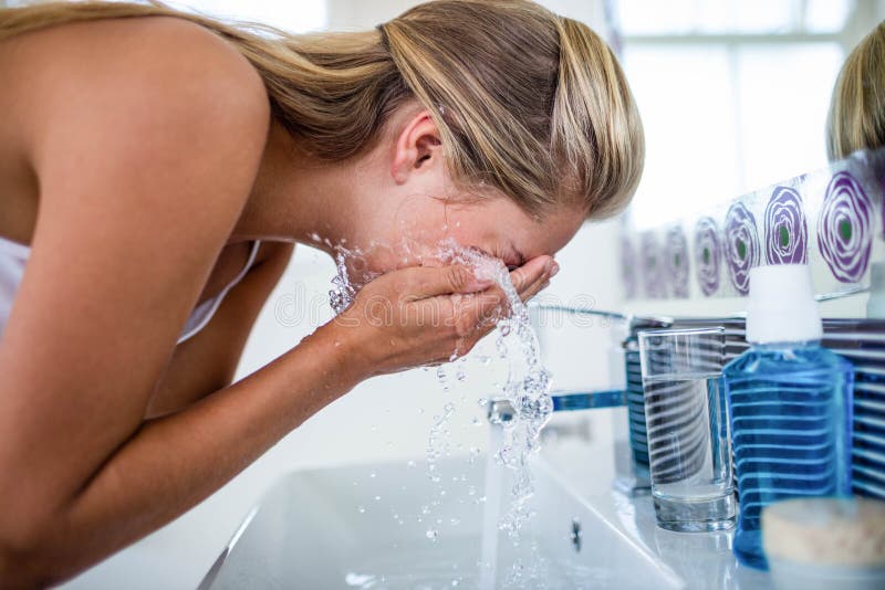 Woman washing her face royalty free stock image