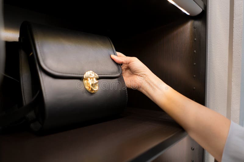 The woman is watching a shoulder bag black from the display