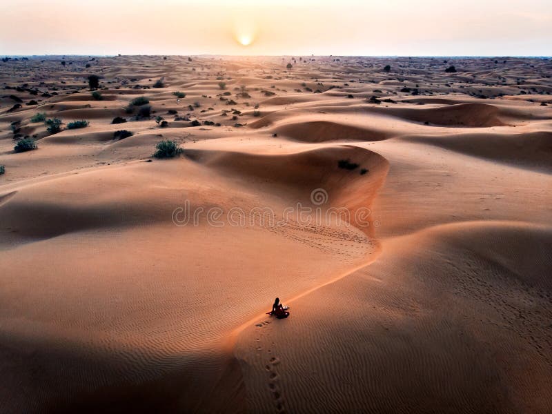 Woman watching sunset in the desert aerial stock image Woman watching sunset in the desert aerial stock image