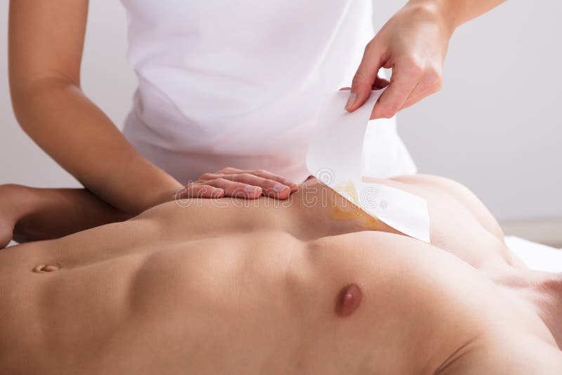 Woman Waxing Man`s Chest With Wax Strip