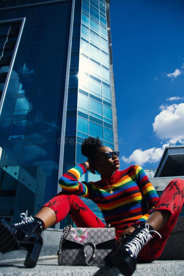 Woman Wearing Blue, Red, and Black Turtle-neck Long-sleeved Shirt and Red Pants Sitting on Ground at Daytime royalty free stock photography Woman Wearing Blue, Red, and Black Turtle-neck Long-sleeved Shirt and Red Pants Sitting on Ground at Daytime royalty free stock photography