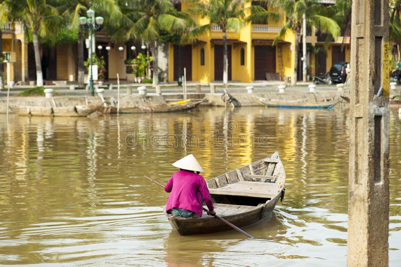 Woman wearing conical hat rowing the boat at Hoi An