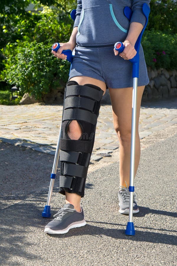 Woman wearing a leg brace with adjustable side panels to immobilize and sup...