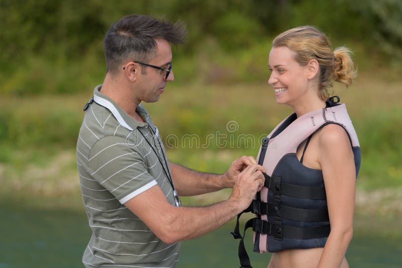 Woman wearing life jacket before water skiing lesson.