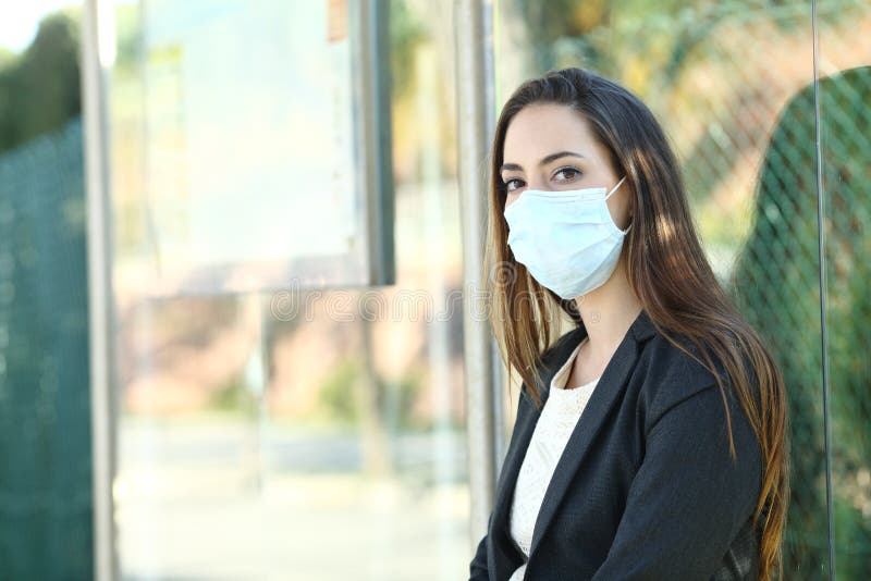Woman wearing a mask to prevent contagion in a bus stop stock image Woman wearing a mask to prevent contagion in a bus stop stock image