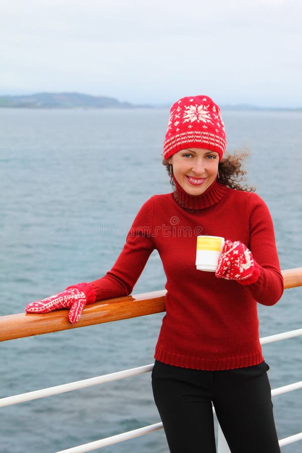 Woman wearing in red hat holds cup of tea