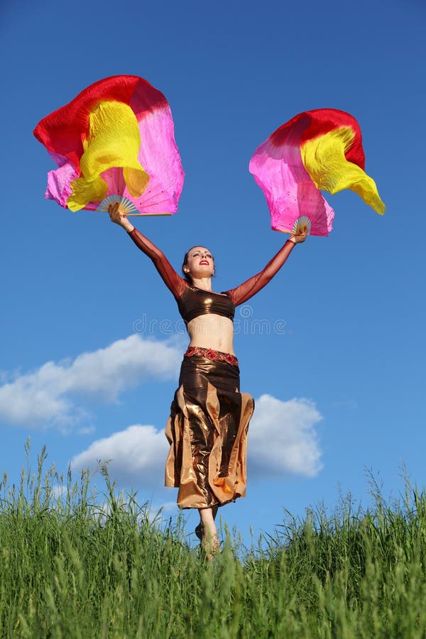 Woman wearing suit dances with veil fans