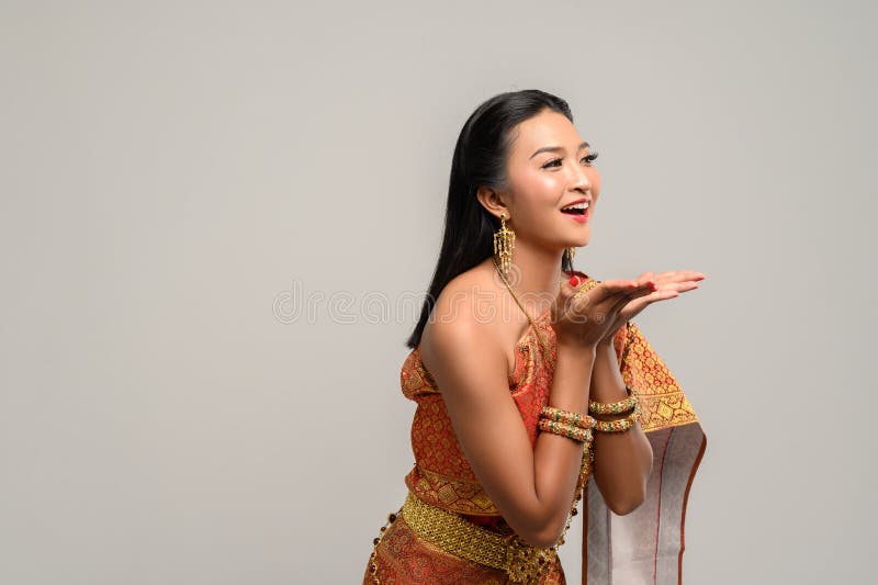 Woman wearing Thai dress that made a hand symbol