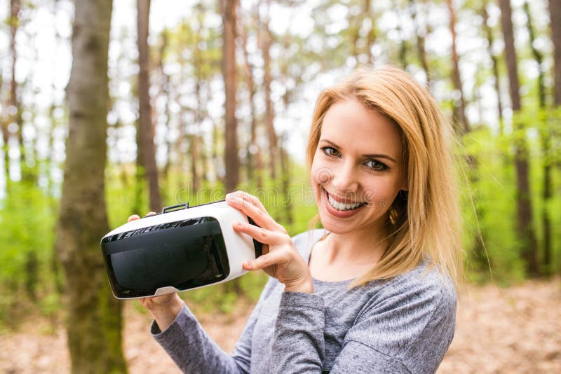 Woman Wearing Virtual Reality Goggles Outside In Spring Nature Stock