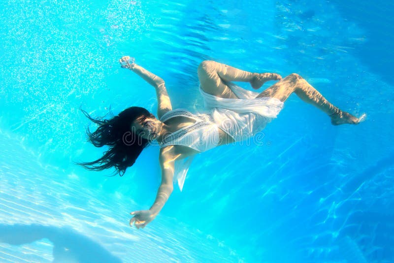 Woman wearing a white dress underwater