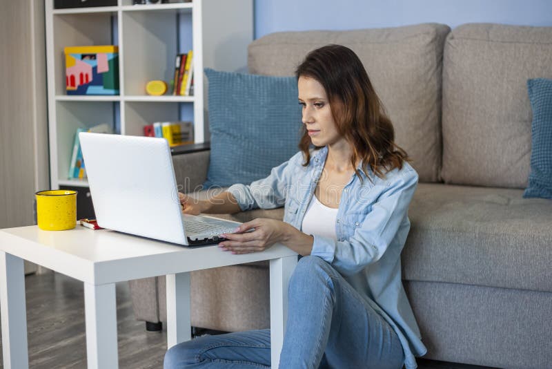 Woman Which Sitting At The Floor Indoors In Home Office Stock