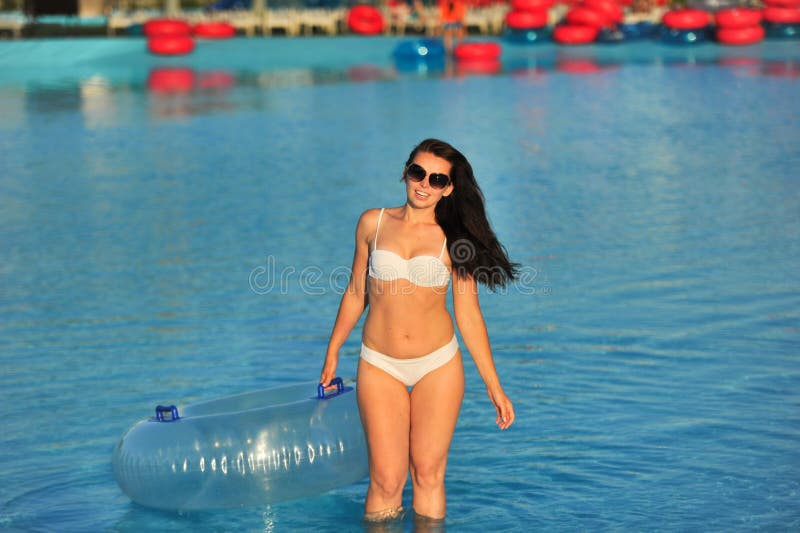A Woman in a White Bathing Suit with an Inflatable Circle in a Water