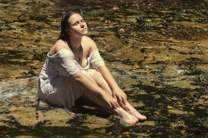 Woman with white dress near stream of water