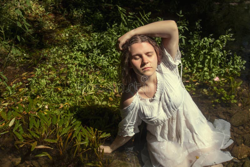 Woman with white dress near stream of water