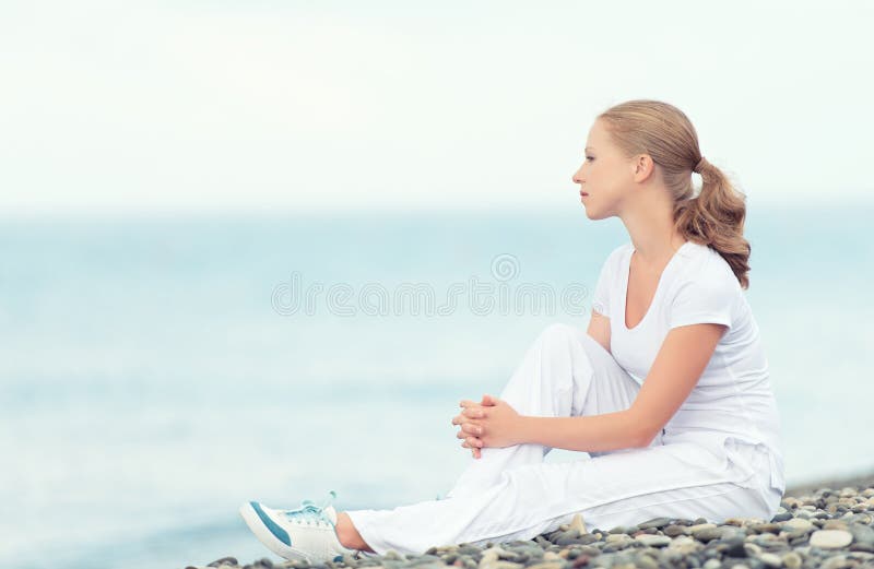 Woman in white relax resting on the sea on the beach