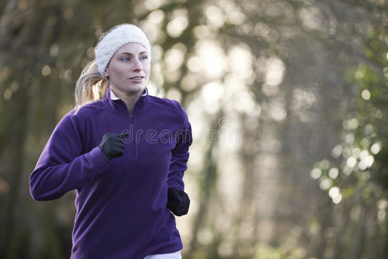 Woman On Winter Run Through Woodland