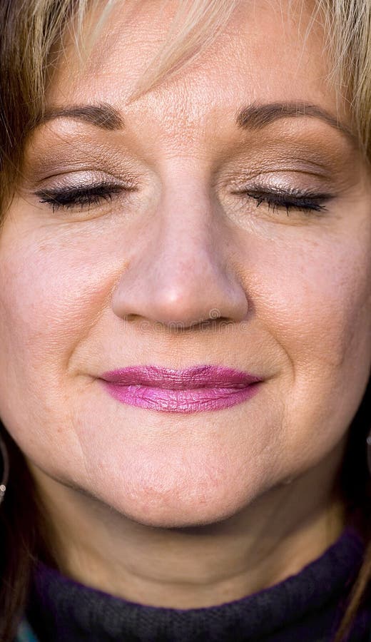 A pretty middle aged woman smiling with her eyes closed. Shallow depth of field. Smiling asking stock images, royalty-free photos and pictures